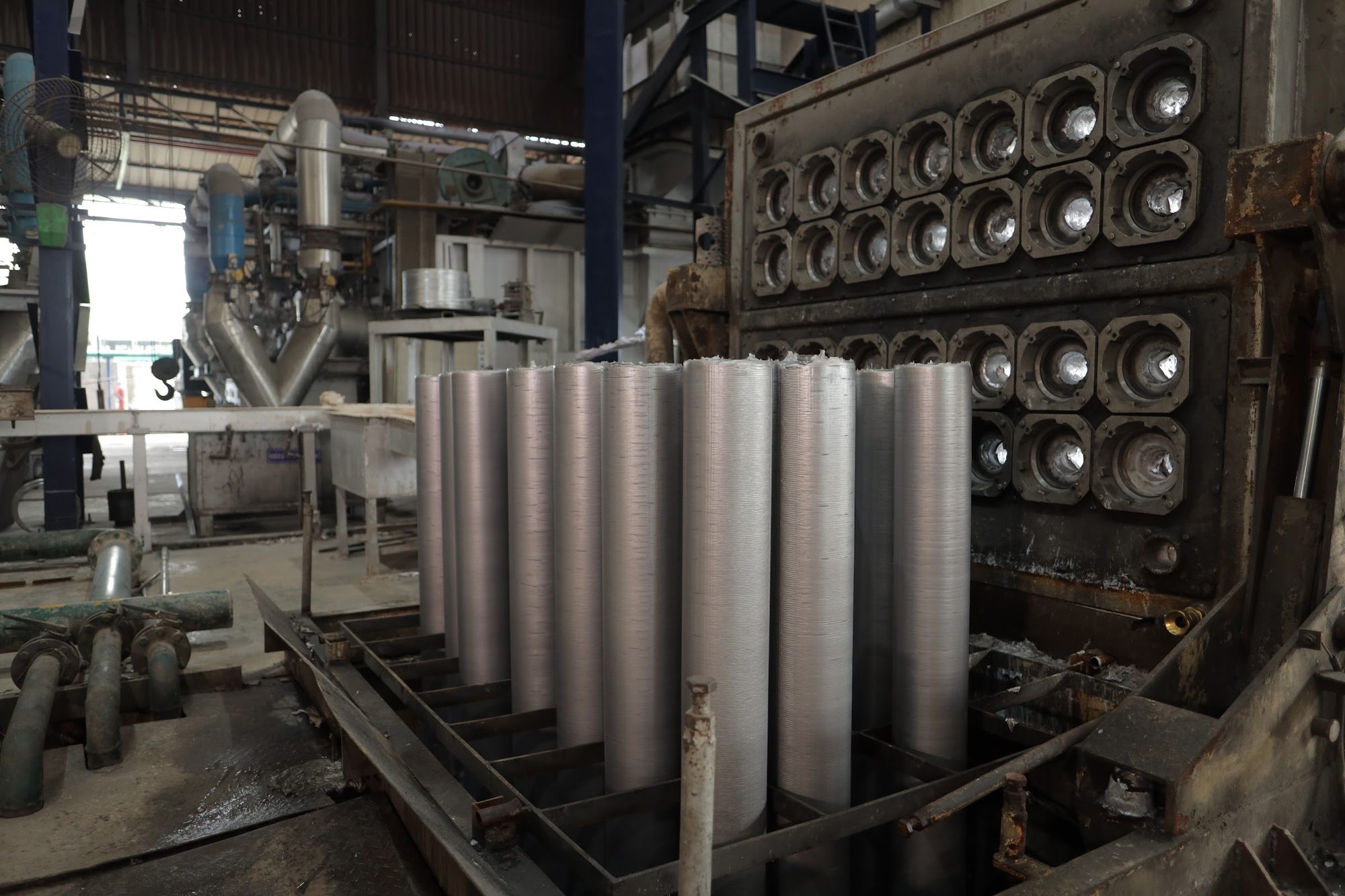 Freshly cast extrusion billets on the casting table in the Banco Aluminium foundry